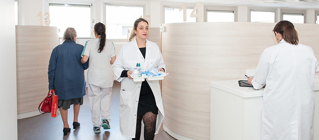 Une patiente et des soignantes se déplacent dans l'hôpital de jour uro-digestif et oncologie.