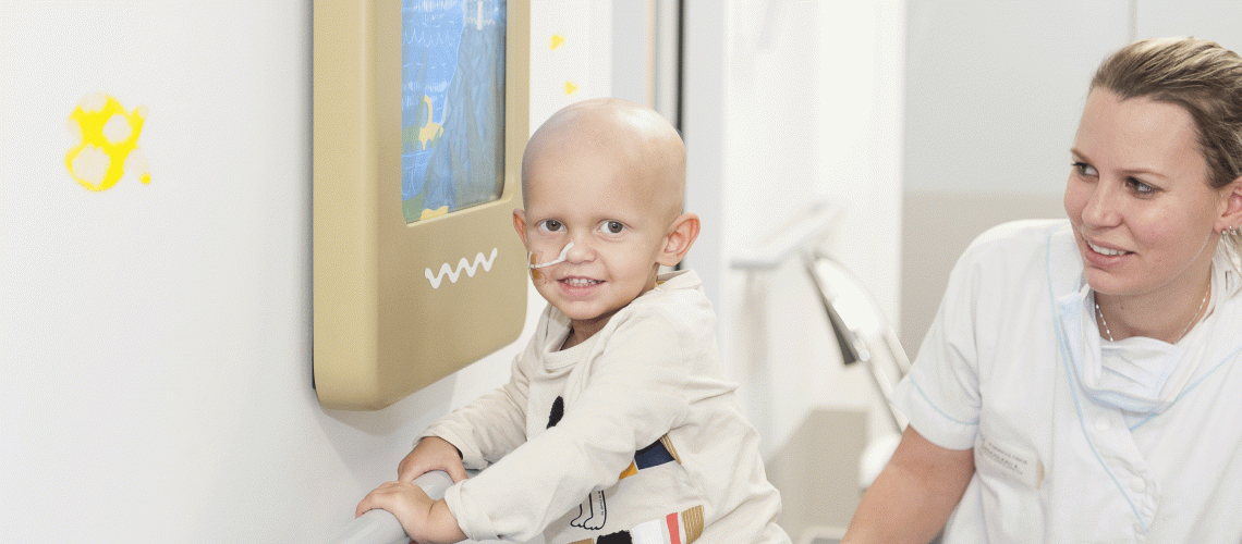 un enfant et une soignante dans un couloir du service d'hémato-immuno-oncologie pédiatrique