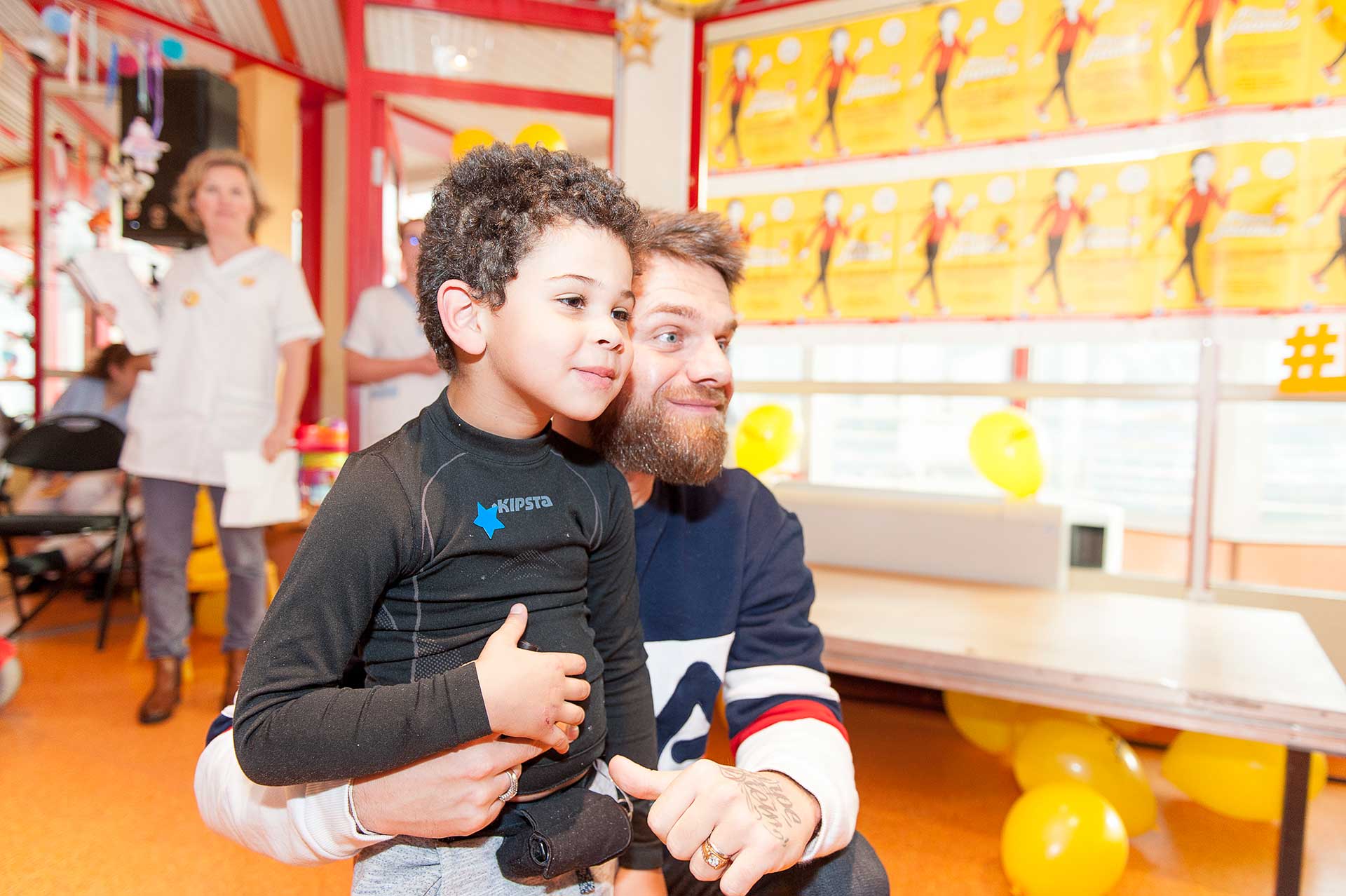 Keen'V pose avec un petit patient à l'occasion de l'inauguration de l'hôpital de jour de médecine de l'adolescent