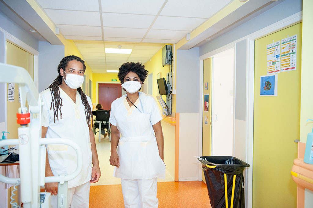 Deux soignants masqués pose dans un couloir de l'USLD Arcadie à l'hôpital de Boucicaut.