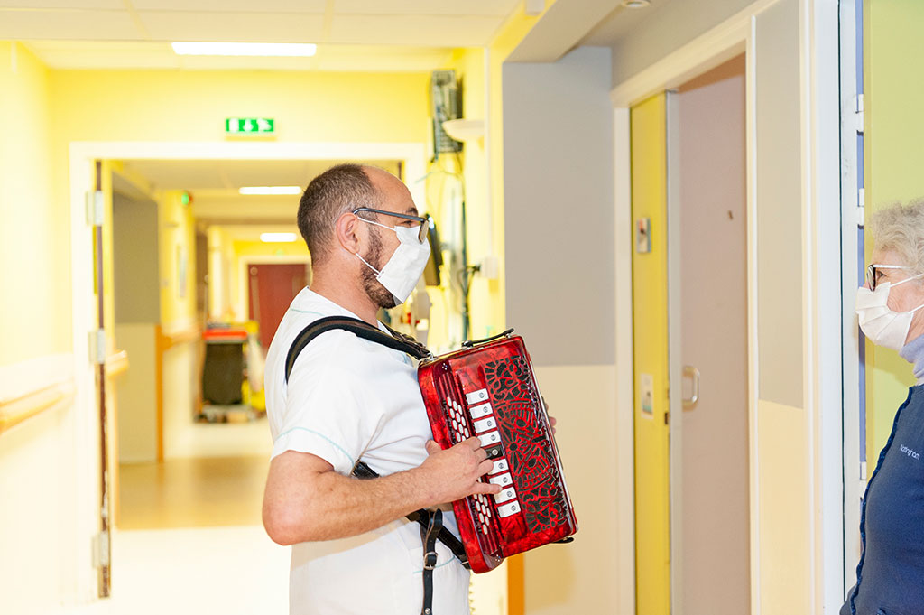 Un animateur joue de l'accordéon dans les couloirs de l'hôpital de Boucicaut.