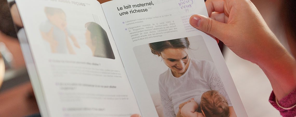 Une femme est en train de lire un livret sur l'allaitement