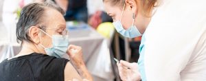 Une infirmière vaccine une dame âgée