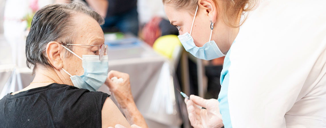 Une infirmière vaccine une dame âgée