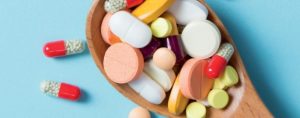 Une quantité importante de médicaments est présentée sur une cuillère en bois.