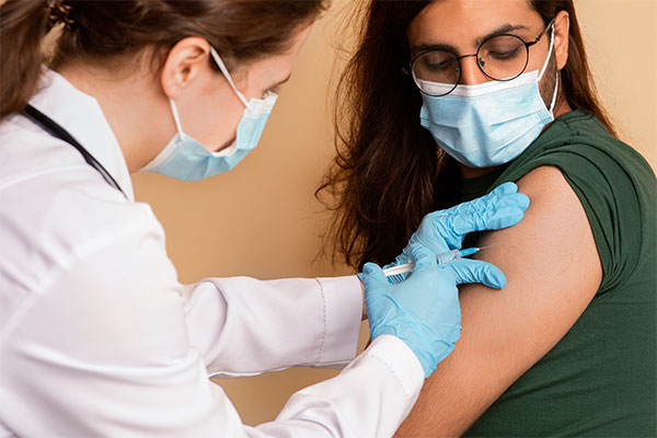 Homme aux cheveux long se faisant vacciner